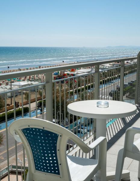 Balcony with sea view, table and chairs.